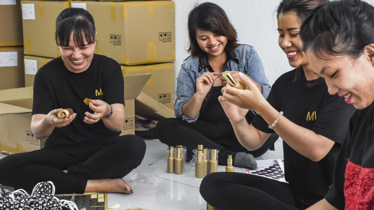 Vietnamese women packing products, sitting on the ground