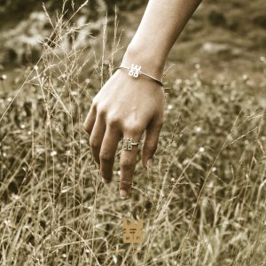 hand with WOO bracelet in nature/grass