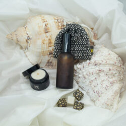 WOO Travel Essentials Gift Set - Luxe en Duurzaam Cadeau met Handgemaakte Kamerspray, Parfum Sachet en Natuurlijke Waxblokjes, Gepresenteerd op een Elegante Schelpen Achtergrond.